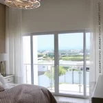 Fotografía de cortinas para casas de playa abiertas en la ventana del balcón del hogar