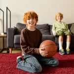Fotografía de dos niños felices jugando en alfombras para alergias que evitan que ellos se enfermen de alguna alergia