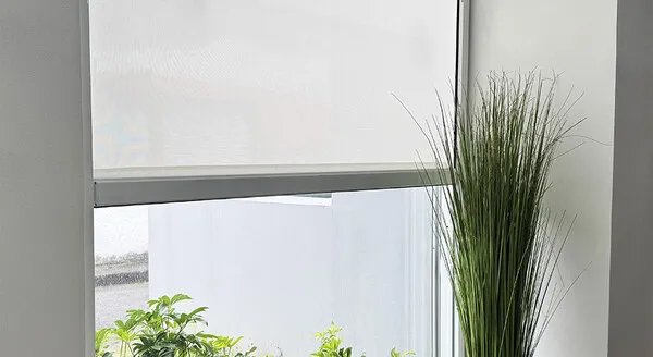 Fotografía de un toldo ZIPRO traslúcido de Canetcam colocado en una casa automatizada pintada de gris claro.