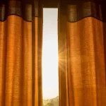 Fotografía de unas cortinas marrones colocadas por alguien que conoce cómo proteger tu casa del calor