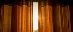 Fotografía de unas cortinas marrones colocadas por alguien que conoce cómo proteger tu casa del calor
