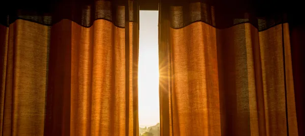 Fotografía de unas cortinas marrones colocadas por alguien que conoce cómo proteger tu casa del calor
