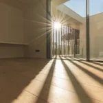 Fotografía del interior de un hogar donde hay decoloración en pisos debido a la falta de cortinas en las ventanas