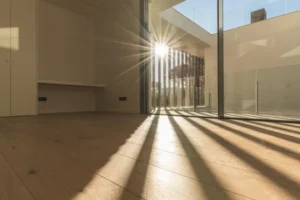 Fotografía del interior de un hogar donde hay decoloración en pisos debido a la falta de cortinas en las ventanas